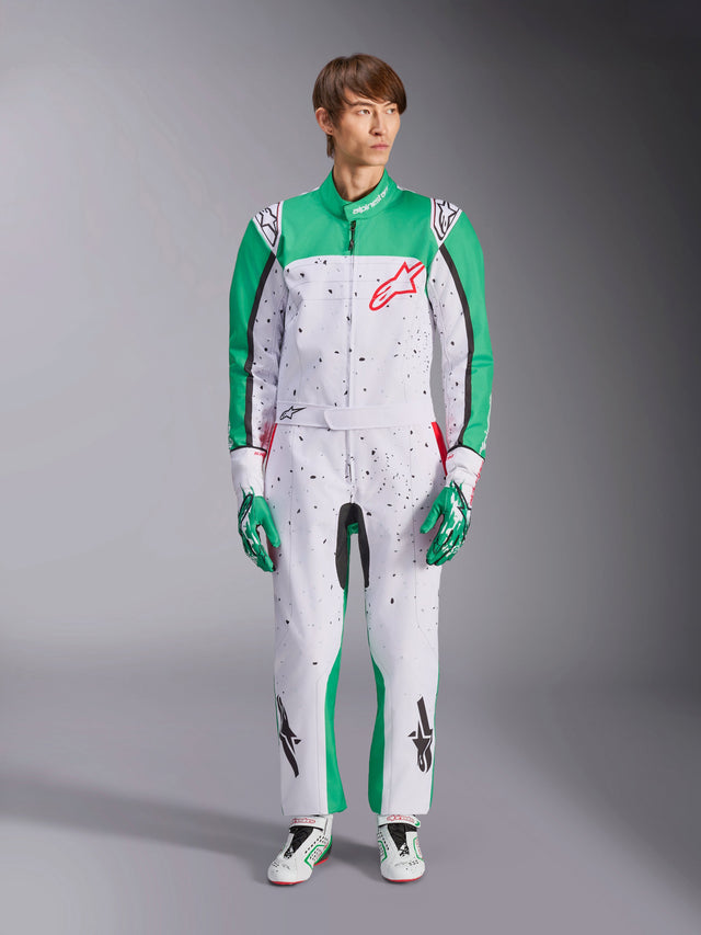 Alpinestars KMX-9 V3 Graphic 6 Suit, vit, grön och röd kartingoverall med svart splatter-mönster, gröna paneler på ärmar och ben, röd Alpinestars-logotyp på bröstet, bärs med matchande racinghandskar och skor