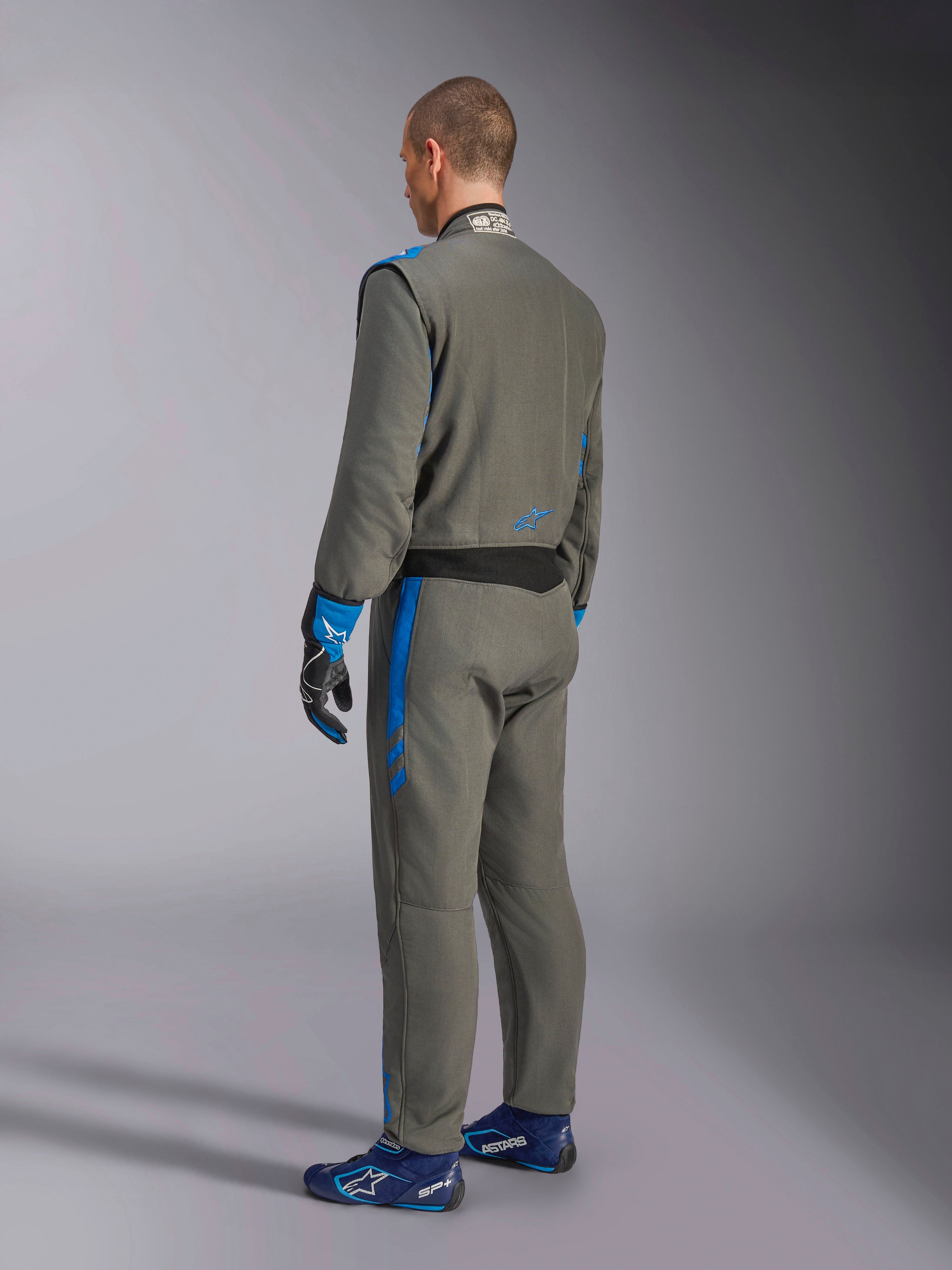 Alpinestars GP Race V3 Suit FIA, bilsportoverall, Anthracite Blue, baksida av modell som bär den grå racingoverallen med blå detaljer, matchande blå handskar och racingskor, professionell design för motorsportutrustning