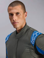 Alpinestars GP Race V3 Suit FIA, antracitblått bilracingställ, närbild på modell som visar den övre delen av designen med blå axelklaffar och vita Alpinestars-logotyper, professionell motorsportutrustning.