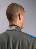 Alpinestars GP Race V3 Suit FIA i Anthracite Blue, detaljvy av kragen bak som visar den vita FIA 8856-2018-homologeringsetiketten, textilkonstruktion med blå axeldetalj.