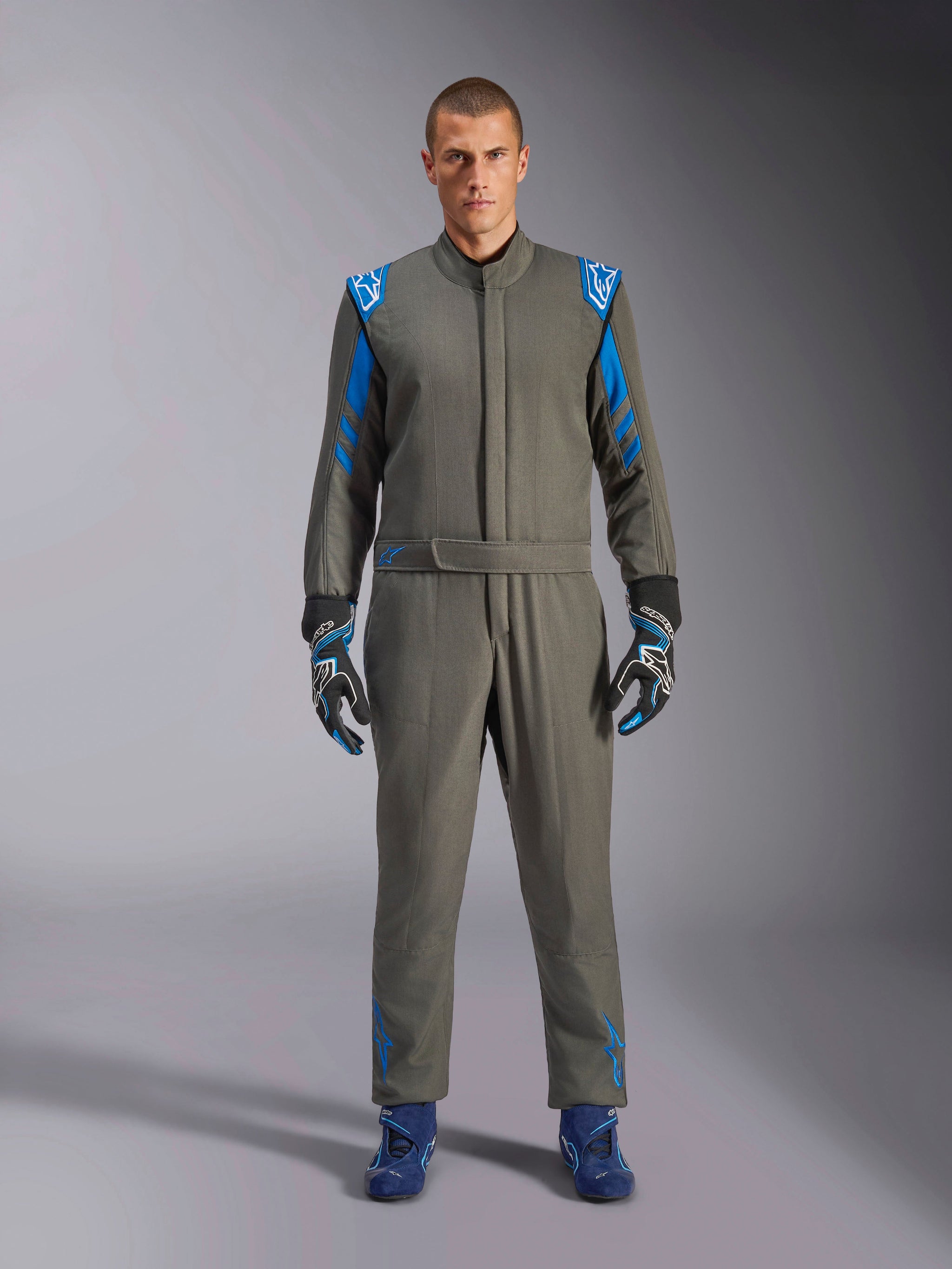 Alpinestars GP Race V3 Suit FIA, antracitblå racingoverall, bärs med matchande handskar och racingskor, med klarblå axelklaffar och ränder på ärmarna, Alpinestars-logodetaljer, professionellt motorsportskydd för banracing