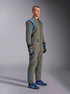 Alpinestars GP Race V3 Suit FIA i Anthracite Blue, racingoverall i ett stycke som bärs av en manlig modell, har klarblå accenter på axlar och anklar, kombinerad med matchande racinghandskar och blå racingskor, professionell motorsportutrustning.