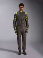 Alpinestars GP Race V3-overall FIA, föraroverall för bilracing, svart och fluorescerande gul, bärs av en modell med matchande racinghandskar och skor, med neongula detaljer på axlar, midja och ärmar, professionell motorsportutrustning