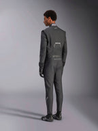 Alpinestars Hypertech V3 Suit, Black Dark Shadow, ryggvy av manlig modell klädd i professionell racingoverall med matchande svarta handskar och skor, lätt Nomex-konstruktion och FIA-certifiering på kragen, athletic-slim passform för motorsport.