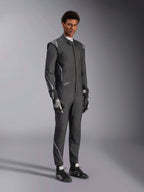 Alpinestars Hypertech V3-dräkt, racingoverall, svart och Dark Shadow, bärs av en manlig modell med matchande svarta handskar och racingskor, atletisk slim fit, har Alpinestars-logotyper och ljusgrå accenter, professionell skyddsutrustning för motorsport