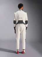 Bakifrån av en modell som bär Alpinestars Hypertech V3-dräkten i vitt, svart och silver, som visar den stora svarta stretchpanelen i ländryggen med 'alpinestars'- och 'RACING AHEAD'-logotyper, svarta armbågsinsatser, FIA-certifieringsetikett på kragen och en atletisk passform designad för professionell racing.