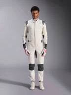 Alpinestars Hypertech V3-dräkt, professionell racingdräkt för bilsport, vit, svart och silver, bärs av en modell med röd-vita handskar och matchande vita racingskor, med svarta kontrastpaneler och Alpinestars-logotyper, atletisk slim fit-design