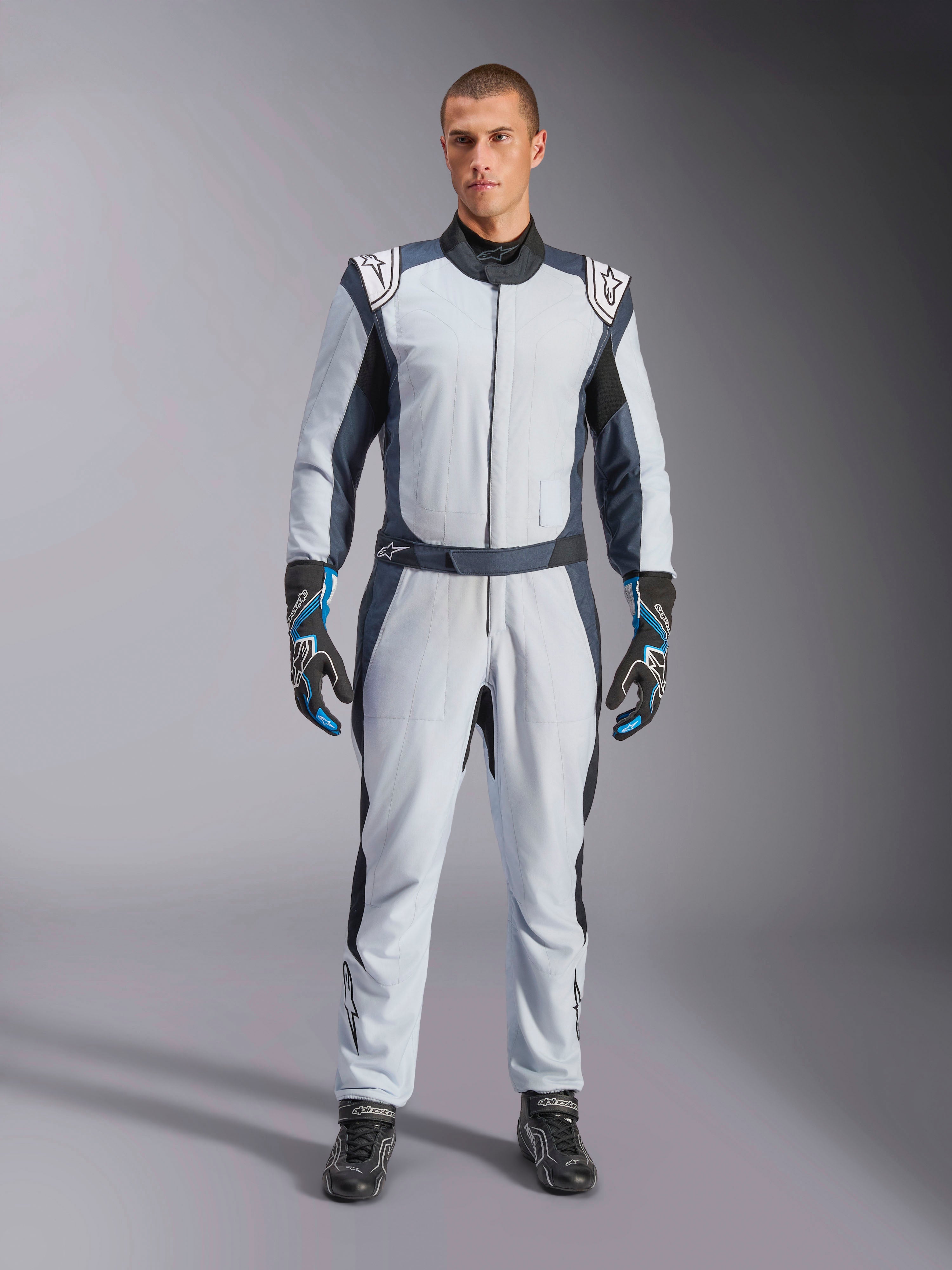 Alpinestars GP Pro Comp V2 FIA MC-ställ, silverblå och asfaltsgrå racingoverall, FIA-certifierat aramidmaterial, på modell.
