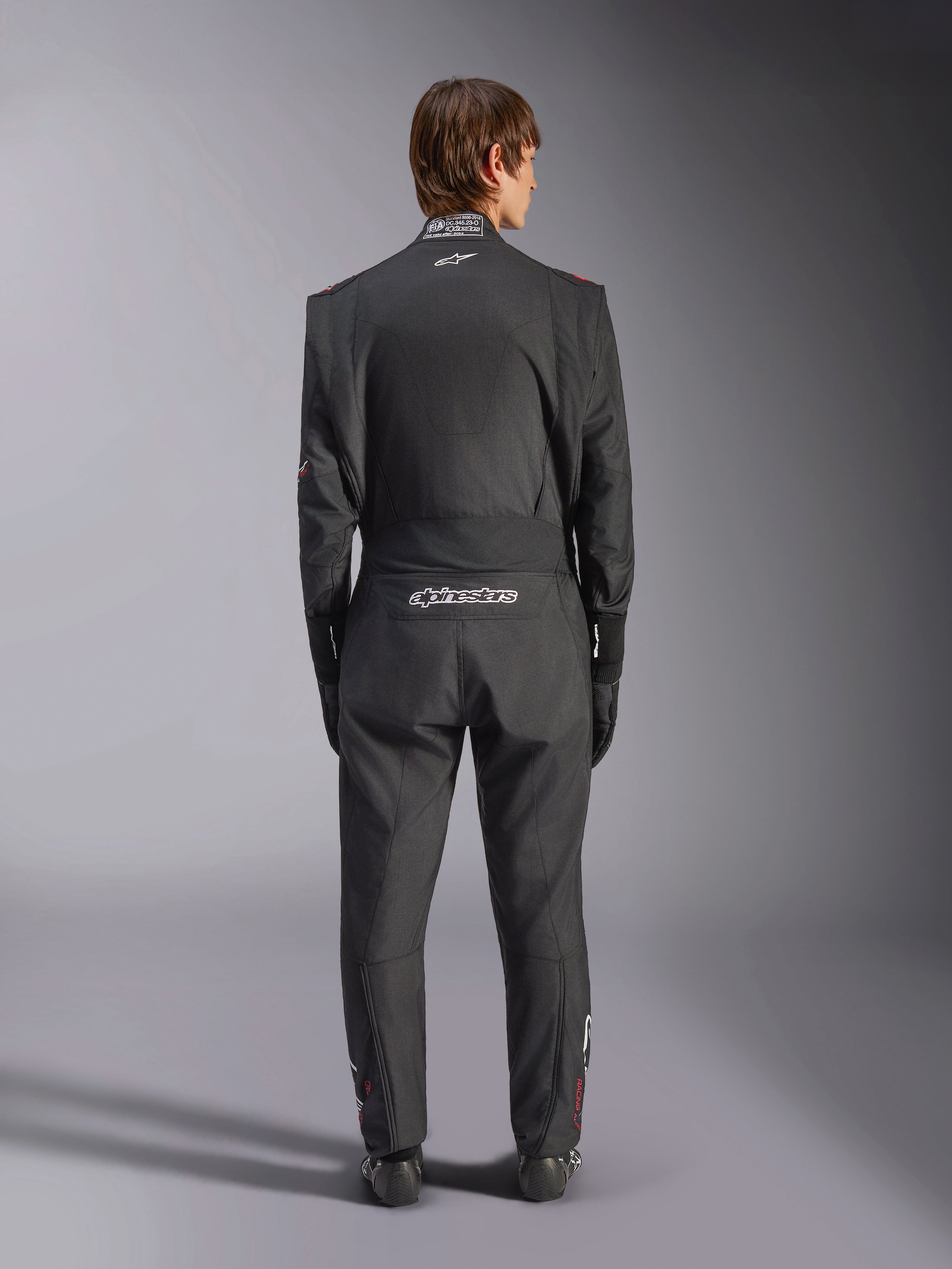Alpinestars GP Tech V4 Suit, Auto Racing Suit, Black and White, back view featuring white Alpinestars branding and FIA certification on the collar, sleek ergonomic fit for professional driver protection