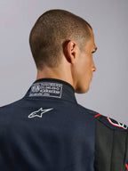 Alpinestars GP Tech V4-overall i marinblått, svart och rött, närbild på kragen baktill med FIA 8856-2018-certifieringsetikett och vit broderad Alpinestars-logotyp, detalj av högpresterande racingoverall