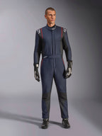 Alpinestars GP Tech V4 Suit, professionell racingoverall i marinblått och svart med röda detaljer, FIA-certifierad racingutrustning i ett stycke, bärs med svarta racinghandskar och skor, förarutrustning för motorsport