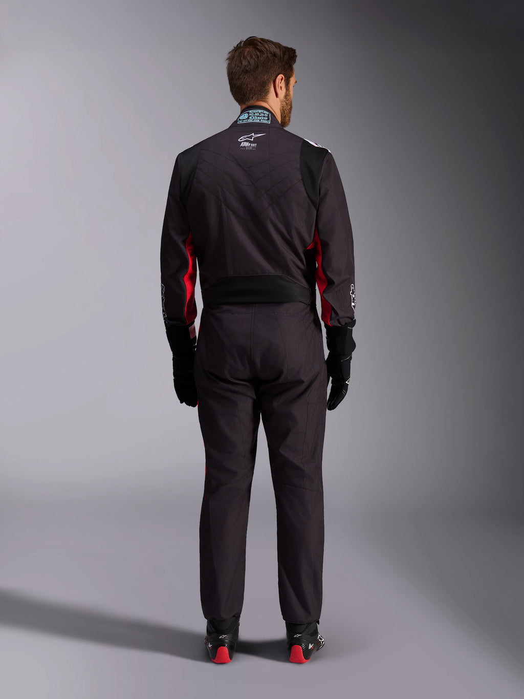 Alpinestars KMX-9 V3 Graphic 3 Suit, kartingdräkt, svart och röd, baksida med stretchpanel i ländryggen och FIA-certifieringsetikett på kragen, stylad med svarta racinghandskar och boots med röda detaljer