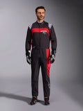 Alpinestars KMX-9 V3 Graphic 3-dräkt, kartingdräkt, svart och röd, helkroppsbild framifrån på en modell, med framträdande röda grafiska paneler och vit logotyp, kombinerad med svarta racinghandskar och skor, professionell motorsportutrustning.