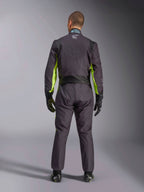 Helbild bakifrån av en person som bär Alpinestars KMX-9 V3 Graphic 3 Suit, kartingoverall i svart och fluorescerande gult, som visar ergonomiska stretchpaneler på ryggen och axlarna, matchad med svarta racinghandskar och skor.