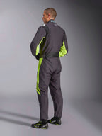 Alpinestars KMX-9 V3 Graphic 3 Suit, kartingoverall, svart och neongul, baksida av modell som visar dräktens endelsdesign med neongula detaljer på sidorna och under armarna, ergonomiska stretchpaneler i ländryggen och justerbart midjebälte, bärs med matchande racingskor.