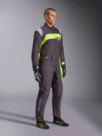Manlig modell bär Alpinestars KMX-9 V3 Graphic 3-overall i svart och neongult, professionell kartingutrustning med livfulla neongula paneler och vita logotypdetaljer, matchad med koordinerade racinghandskar och skor, studiobakgrund