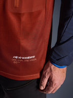 Alpinestars Maxdura Dual Jersey, äventyrströja för motorcykel, rostbrun och marinblå, närbild som visar meshtyget på torson och den marinblå vävda ärmen, vit Alpinestars 'One Goal One Vision'-logotyp på den nedre fållen.