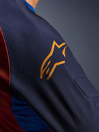 Alpinestars Maxdura Dual Jersey, närbild på Mood Indigo-ärmen med en gul Alpinestars-logotyp, som visar integrerad spacer mesh-stoppning och Rust Brown mesh-tyg på torson, teknisk äventyrsklädsel för motorcykel