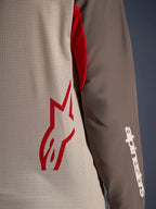 Alpinestars Maxdura Dual Jersey, Aluminum Walnut, närbild som visar den ventilerade torson i mesh med en röd stjärnlogotyp och en brun nötningsbeständig ärm med en vit Alpinestars-text, teknisk adventure- och dual-sport-motorcykelutrustning