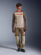 Alpinestars Maxdura Dual Jersey i Aluminum Walnut, adventure-motorcykeltröja med beige mesh-torso och bruna ärmar, röd krage och vågrätt bröstband med Alpinestars-logotyp, buren med matchande adventure-byxor och handskar