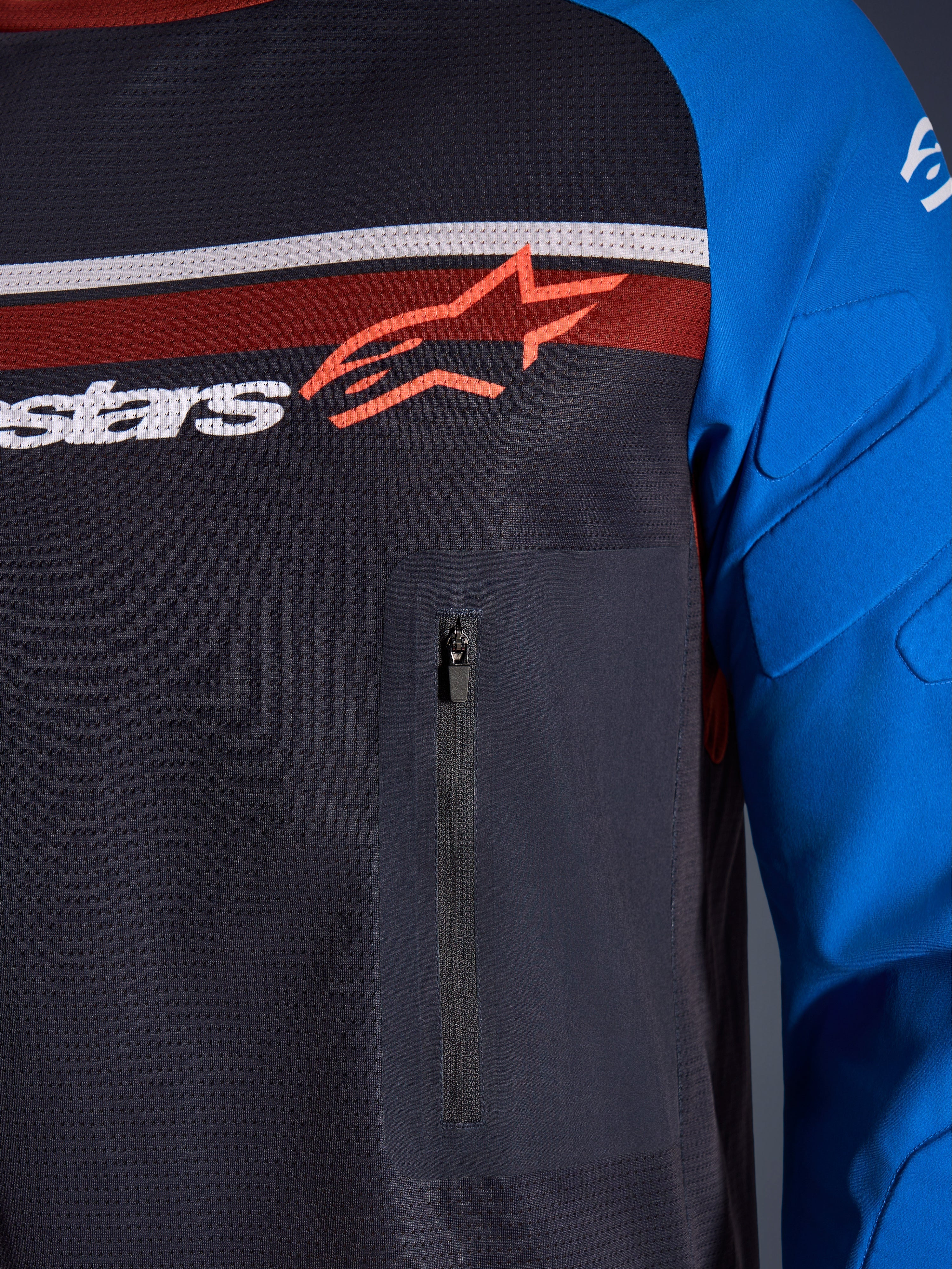 Alpinestars Maxdura Dual Jersey, närbild på bröst och ärm, mörkgrå och kungsblå, med bröstficka med dragkedja, ventilerande mesh-bål och integrerad vaddering på ärmarna, Alpinestars-logotyp över röda och vita ränder