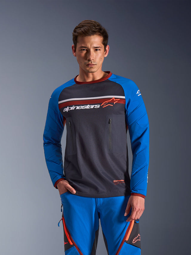 Alpinestars Maxdura Dual Jersey, jersey i Deep Gray och Royal Blue med orange detaljer, helmaskkonstruktion på bålen och bröstfickor med dragkedja, matchad med blå äventyrsbyxor, teknisk dual-sport- och terrängutrustning