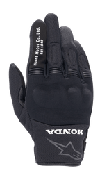 Alpinestars Honda Copper Glove, svart urban motorcykelhandske, texturerad mesh-konstruktion, vit text 'Honda Motor Co. Ltd. Est. 1948' på pekfingret, 'HONDA'-logotyp och Alpinestars-stjärna på handleden, hårt knogskydd, lätt utrustning för landsvägskörning