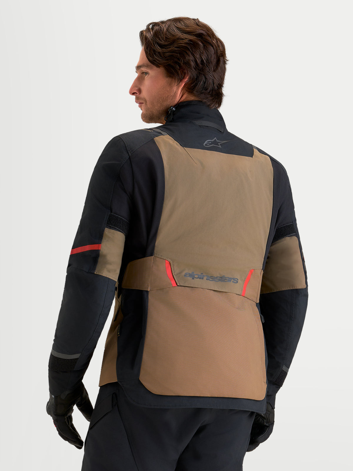 Alpinestars St 7 V2 2L Gore-Tex jacka, äventyrsmotorcykeljacka för herr i valnötsbrun och svart, vy bakifrån på manlig modell som visar laminerat Gore-Tex-skal
