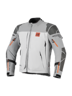 Alpinestars Nazca 3L GORE-TEX PRO-jacka, motorcykeljacka för äventyr, mörkgrå och mellangrå med orangea dragkedjedetaljer, All Terra-logotyp på bröstet, Superfabric-förstärkningar på axlar och armbågar, flera ventilationsöppningar med dragkedja, robust touringdesign