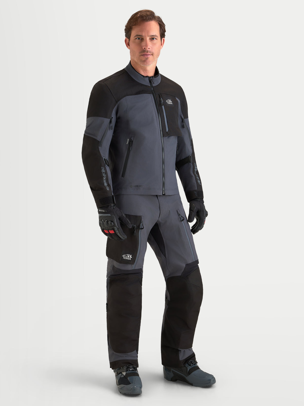 Alpinestars Arenis Gore-Tex gear set, äventyrsmotorcykeljacka och byxor för herr i svart och mörkgrå, framifrån på modell som bär matchande vattentät skyddsutrustning