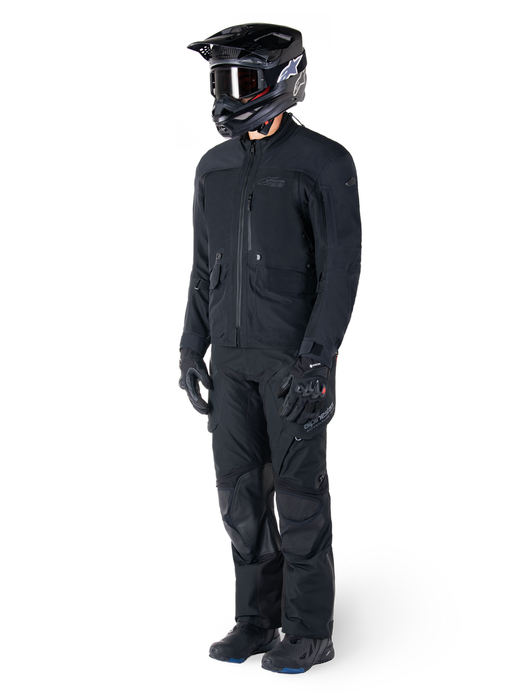 Motorcyklist klädd i Alpinestars St-7 Prime GORE-TEX-jacka i svart, matchande adventure touring-outfit med svarta byxor, svart hjälm med goggles och handskar, med en strömlinjeformad och funktionell design för prestanda i alla väder.
