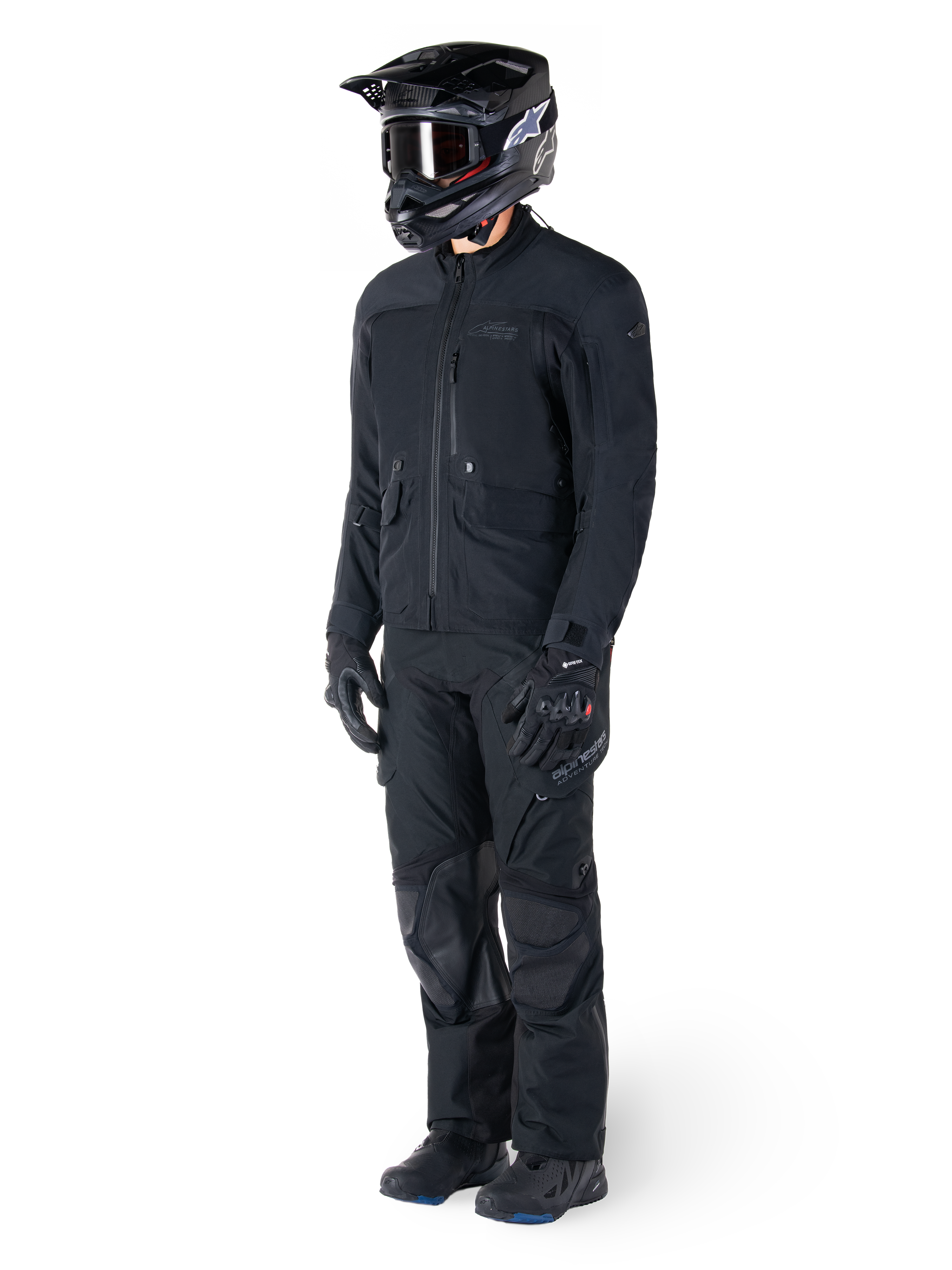 Motorcyklist klädd i Alpinestars St-7 Prime GORE-TEX-jacka i svart, matchande adventure touring-outfit med svarta byxor, svart hjälm med goggles och handskar, med en strömlinjeformad och funktionell design för prestanda i alla väder.
