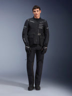 Alpinestars ST-7 2L GORE-TEX-jacka, motorcykeljacka för adventure-touring, svart och mörkgrå, bärs med matchande svarta körbyxor och handskar, med flera cargo-fickor, reflexdetaljer och Alpinestars Exploration Equipment-logotyp på bröstet, funktionell design för väg- och terrängkörning