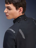 Alpinestars ST-7 2L GORE-TEX-jacka, svart och mörkgrå motorcykeljacka, närbild av kragen som visar justering med dragsko och Tech-Air-etikett, med grå reflexdetaljer och logotyp på axeln.