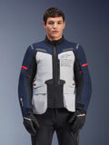 Alpinestars ST-7 2L GORE-TEX-jacka, motorcykeljacka för äventyrstouring, isgrå och mörkblå med röda detaljer, vattentät och andningsbar, bärs av en modell med svarta handskar, med Alpinestars Exploration Equipment-logotyp på bröstet