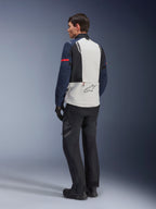 Alpinestars ST-7 2L GORE-TEX-jacka i Ice Gray, Dark Blue och Black, vy bakifrån på modell, ljusgrå ryggpanel med Alpinestars-logotyp, mörkblå ärmar med röd rand, kombinerad med svarta adventure-byxor och stövlar, motorcykel-touringutrustning