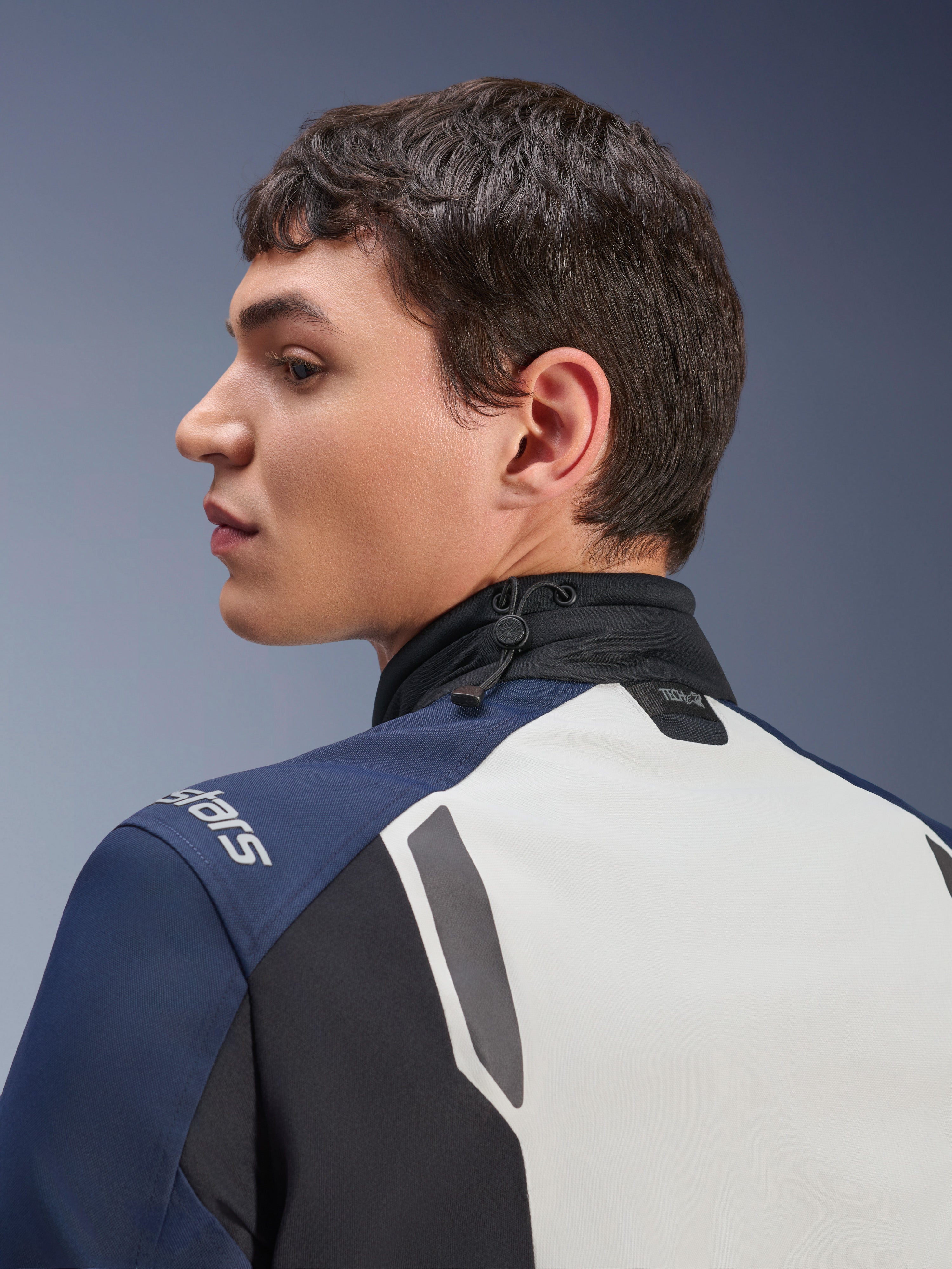 Alpinestars ST-7 2L GORE-TEX-jacka, närbild i profil av rygg- och nackpartiet, Ice Gray, mörkblå och svart, med justerbar krage med stötdämpande snodd och Tech-Air-märkning, premium motorcykeljacka för äventyrstouring.