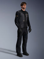 Manlig modell som bär Alpinestars ST-7 2L GORE-TEX-jacka i Deep Gray Black och Dark Khaki, kombinerad med svarta adventure-byxor och handskar, vattentätt laminerat skal med cargo-fickor och teknisk design, idealisk för adventure touring.