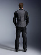 Alpinestars ST-7 2L GORE-TEX-jacka, Deep Gray Black och Dark Khaki, baksida på en modell, adventure-motorcykeljacka för touring med grå ryggpanel och svarta förböjda ärmar, bärs med matchande svarta byxor.
