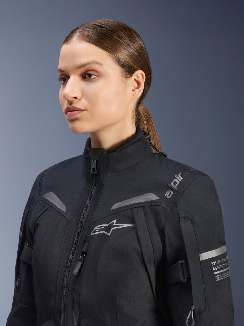 Alpinestars Stella ST-7 2L GORE-TEX jacka för damer, svart, med bröstlogotyp och tekniska koordinater på armen, vattentät textilkonstruktion med hög krage för touring, studioporträtt av en kvinnlig förare