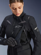 Alpinestars Stella ST-7 2L GORE-TEX-jacka för damer i Black Dark Gray, detaljerad vy av bröstets ventilationspanel öppen för att visa meshfodret, med Alpinestars-logotyp och märke på axeln, designad för adventure road-touring.