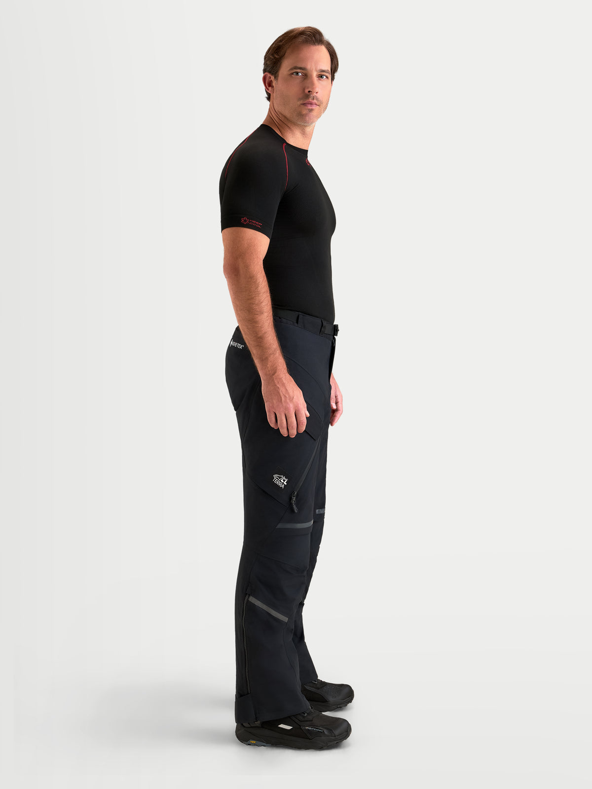 Alpinestars St 7 V 2 2 L Gore Tex byxor, svarta äventyrsmotorcykelbyxor för herr, sidoprofil som visas av modell med vattentät konstruktion och cargofickor