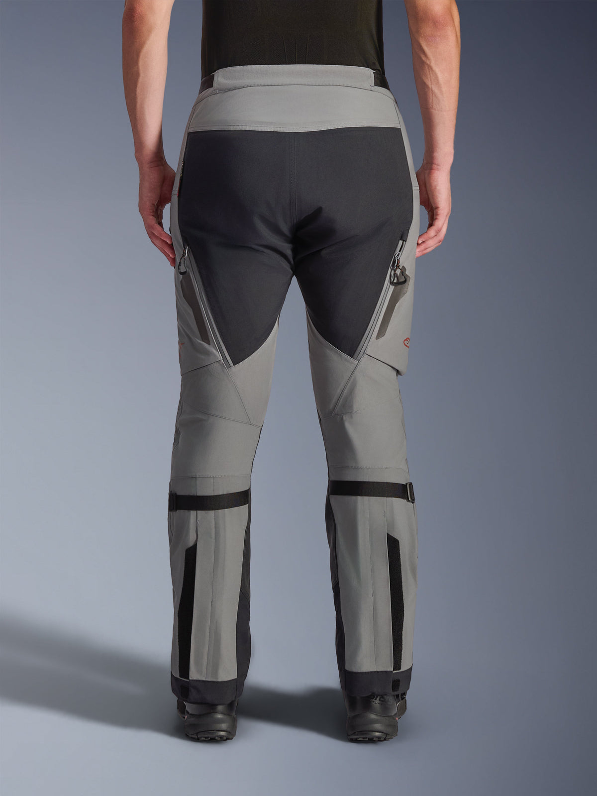 Alpinestars Nazca 3L GORE-TEX PRO-byxor, äventyrsmotorcykelbyxor, mörkgrå och svart, baksida, med ventilationsöppningar med dragkedja på låren, vadvolymjusterare och förstärkta sätespaneler, designade för extrem terrängkörning.