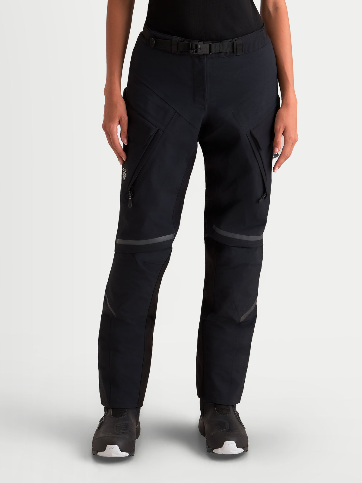 Alpinestars Stella ST-7 V2 Gore-Tex byxor, svarta äventyrsmotorcykelbyxor för dam med cargofickor, framifrån på modell som bär vattentät skyddsutrustning med midjeband