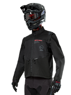 Alpinestars Pro-Dura Jacket, Off-Road Motorcycle Jacket, Black with red and grey branding, features zippered front pockets and high collar, worn with a black motocross helmet and gloves for enduro racing