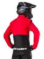 Alpinestars Pro-Dura jacka, offroad-endurojacka, röd och svart med vit Alpinestars-logotyp på den bakre fållen, bärs av förare bakifrån med en svart motocrosshjälm, rallyinspirerad design för aggressiv trailkörning