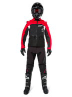 Motocrossförare i komplett offroad-utrustning, Alpinestars Pro-Dura-jacka i svart, klarröd och vit, svarta byxor med röda detaljer, svart hjälm med röda goggles, svarta och vita stövlar, matchande outfit för enduro- och trailkörning