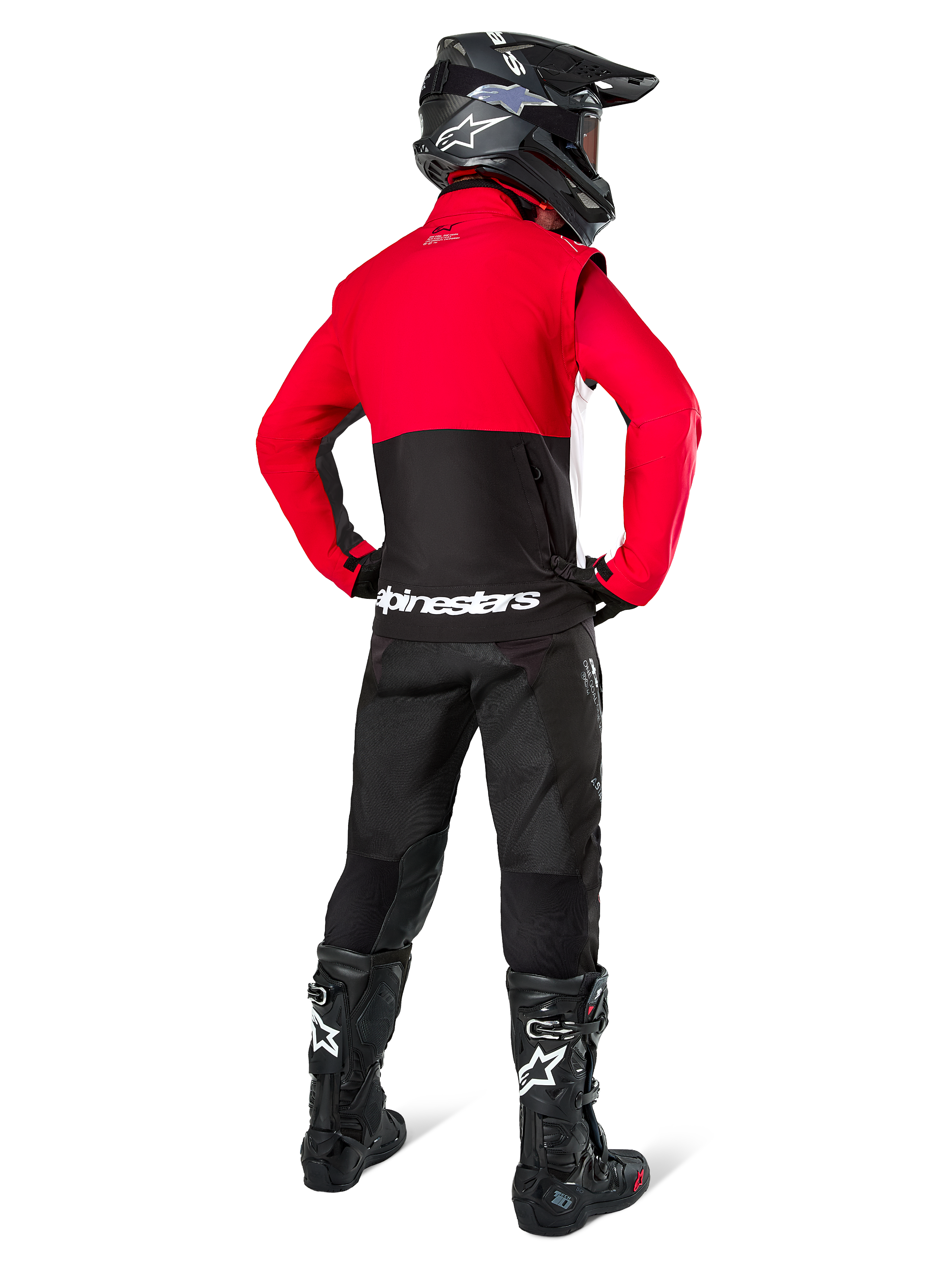 Motocrossförare sedd bakifrån iklädd Alpinestars Pro-Dura-jacka i svart, klarrött och vitt, kombinerat med svarta byxor, svart hjälm och svarta off-road-stövlar, med röd överdel och svart underdel samt vit Alpinestars-logotyp över ryggen.