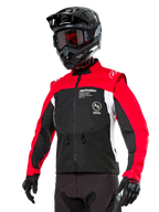 Alpinestars Pro-Dura-jacka, endurojacka för offroad, svart med klarröda och vita färgfält, bärs av en förare med svart hjälm och goggles, framfickor med dragkedja och Alpinestars-logotyp, hållbar textilkonstruktion för trailkörning