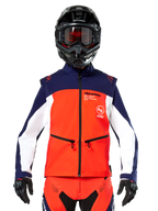 Alpinestars Lite-Dura Softshell Jacket in Navy, Hot Orange, and White, front view on a rider wearing a black helmet and goggles, featuring a color-blocked technical design with zippered hand pockets and Alpinestars branding, versatile gear for enduro and off-road riding